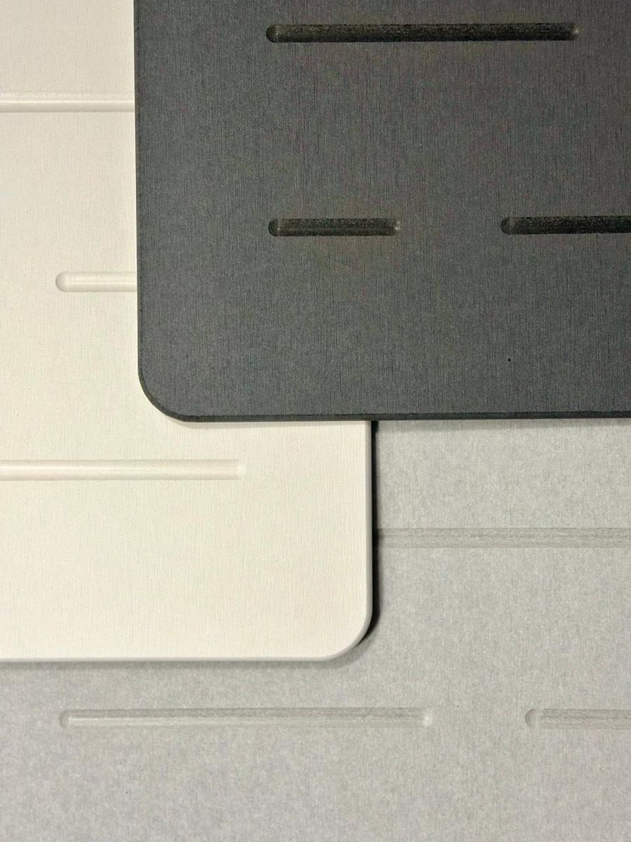 Los tres tapetes, blanco, gris claro y gris oscuro, uno sobre otro
