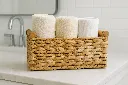 Cesta de mimbre con toallas blancas.webp
